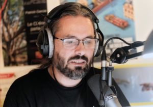 Fred derrière un micro, un casque sur les oreilles.