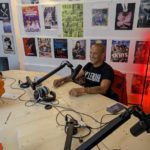 Sam Berrandou assis devant un micro, tout sourire
